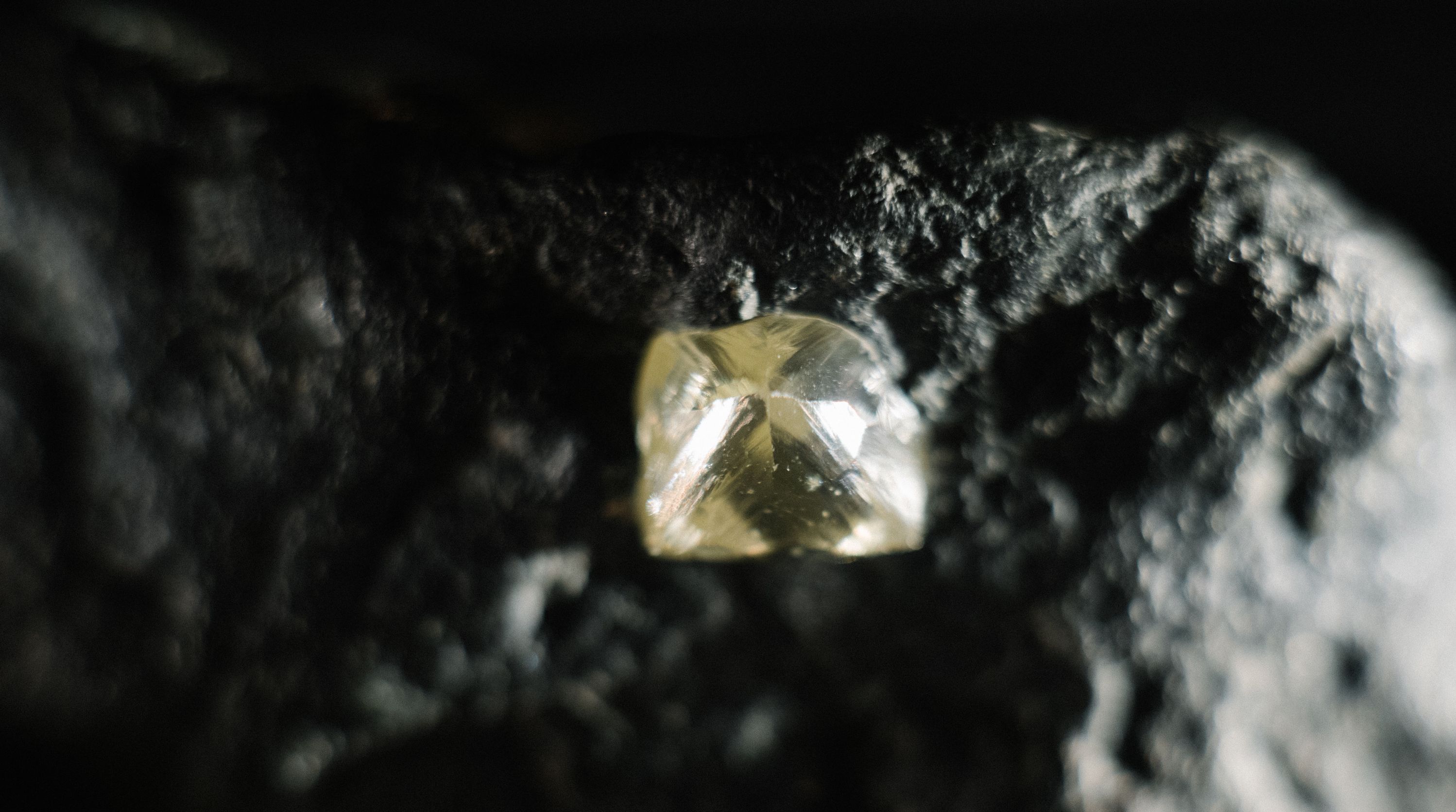 A close up of a diamond on a black rock