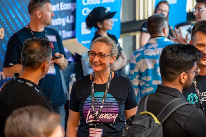 Attendees in Latency T-shirts and lanyards talking at Latency 2021