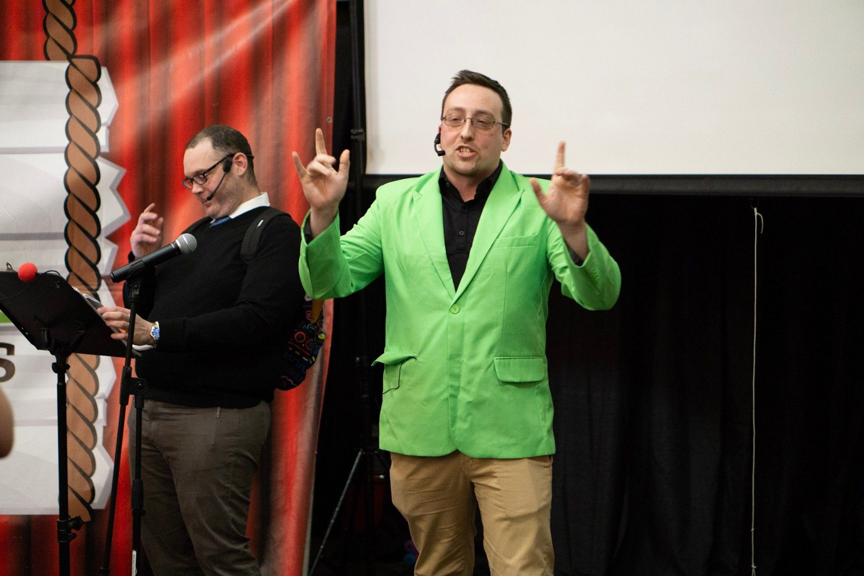 trivia host in a green jacket hyping up the crowd