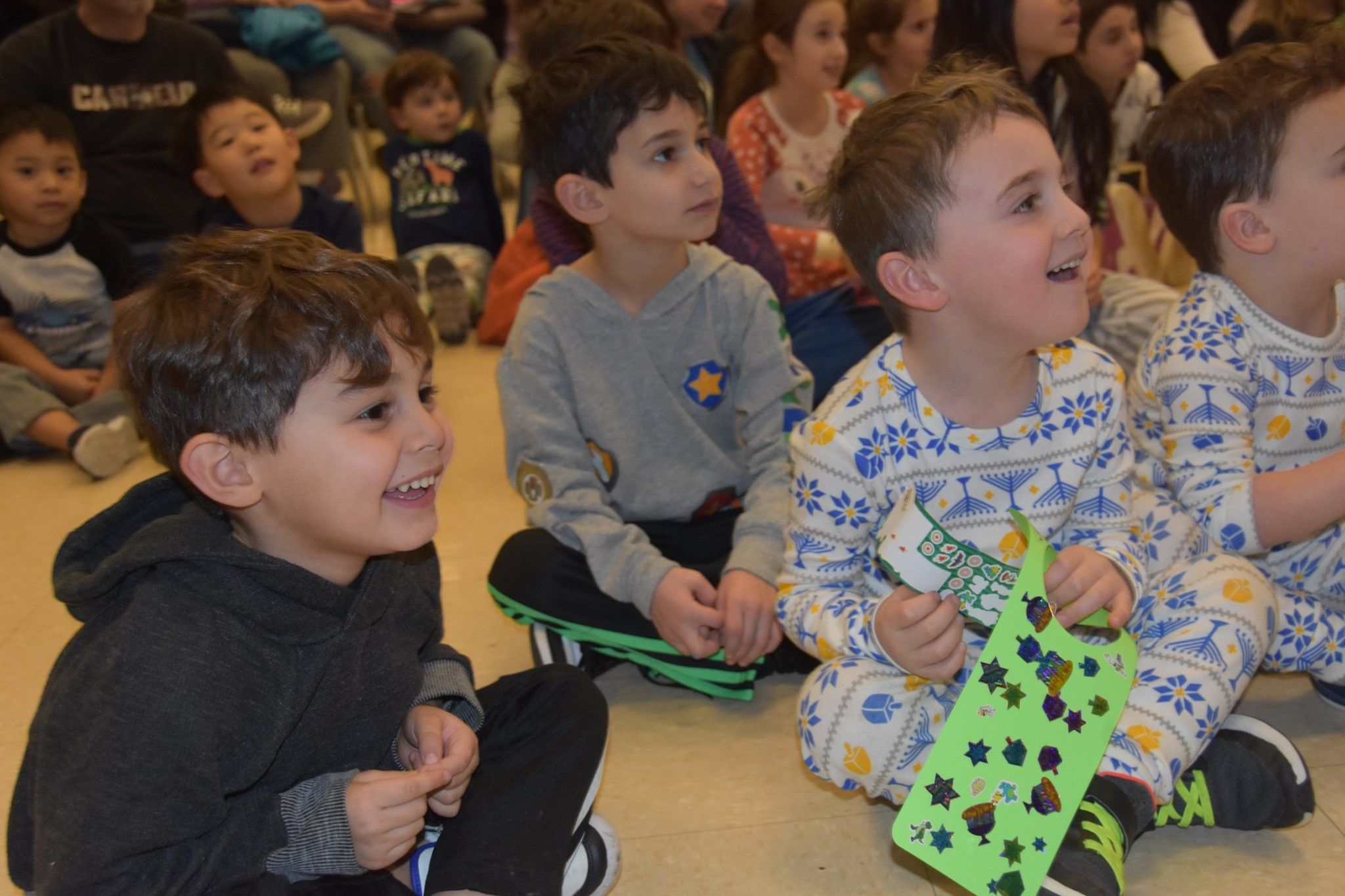 young children sitting on the floor in an audience looking excited
