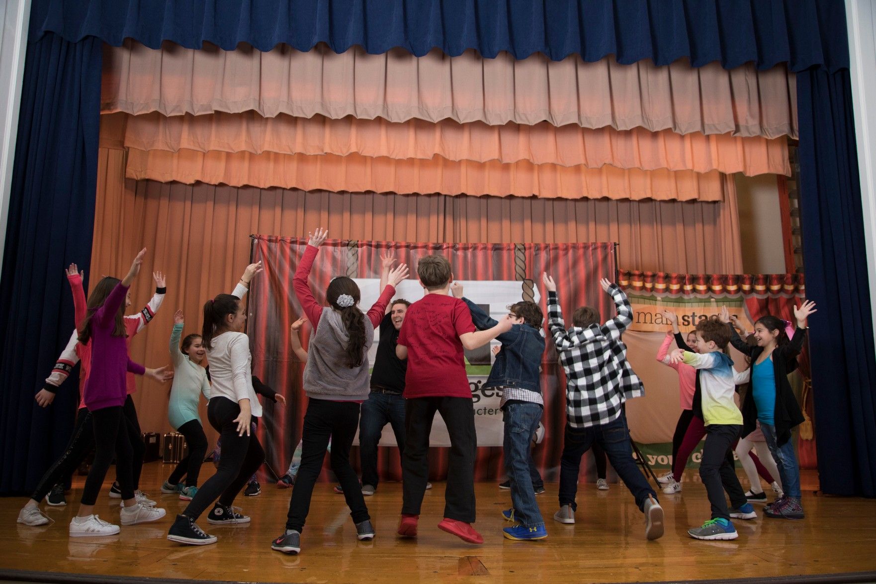 children jumping around on theater stage