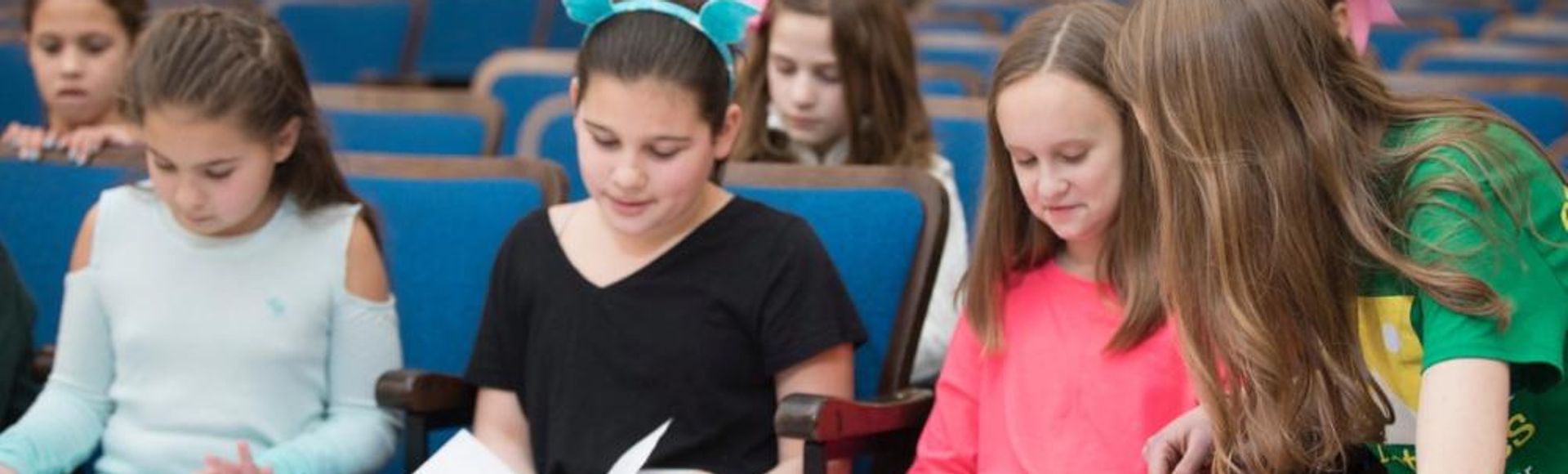 school kids sitting reading play scripts