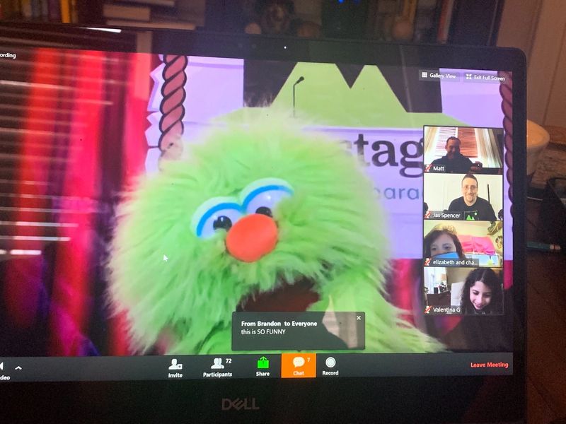 photo of a computer screen on zoom with a green puppet and kids on video chat