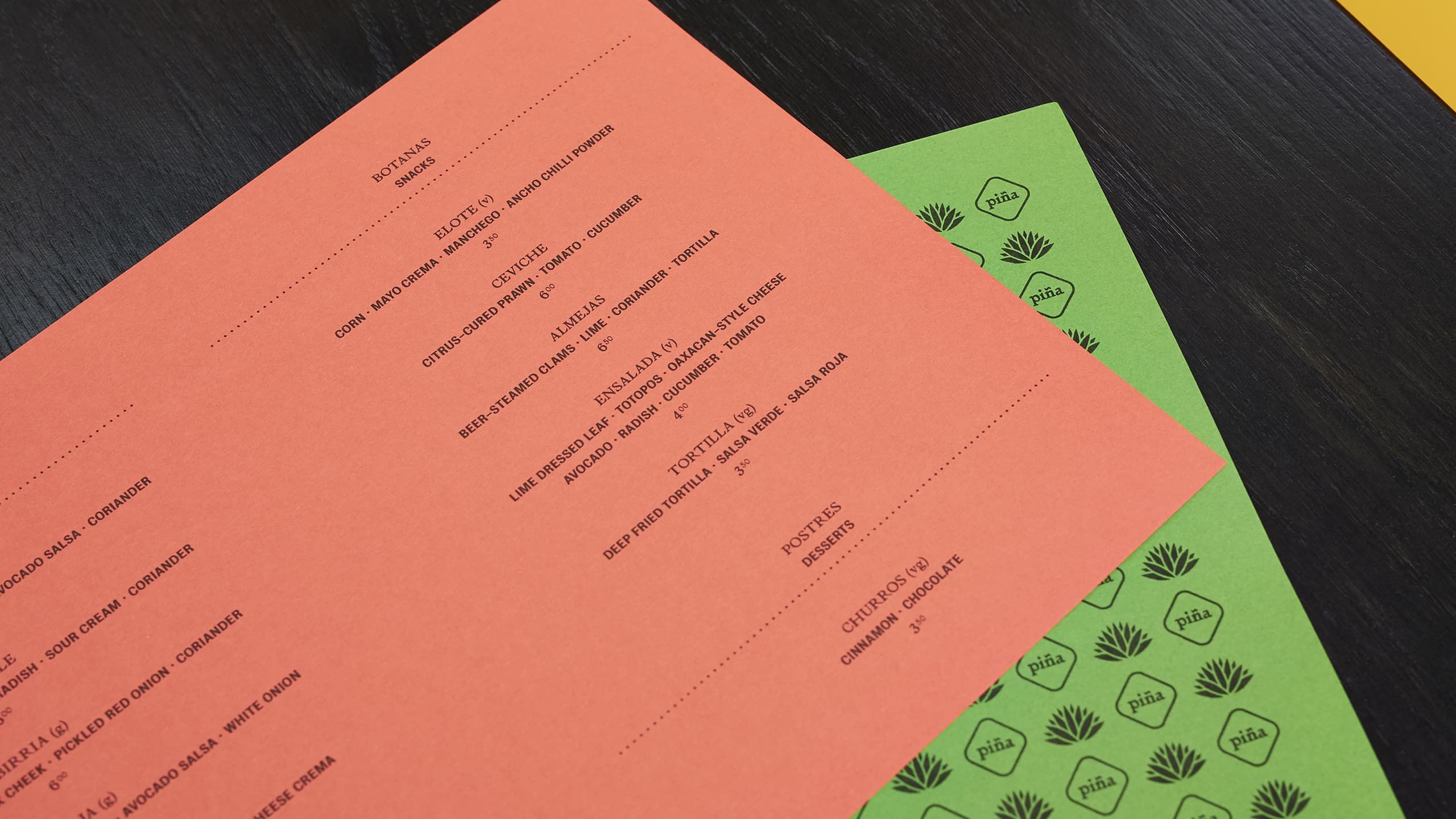 piña's food menu laid upon a table within one of their booths.