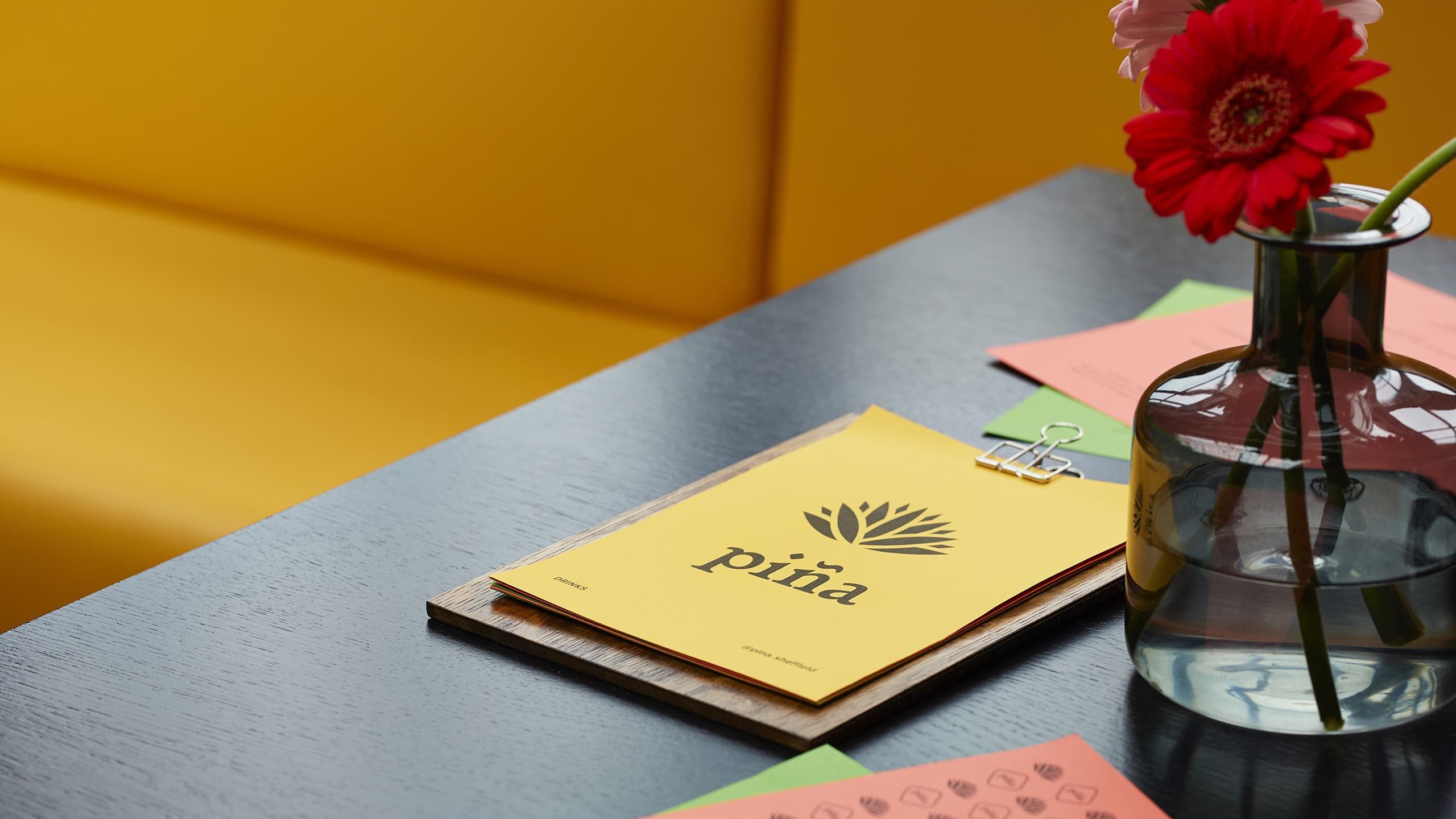 piña's drinks menu laid upon a table within one of their booths.