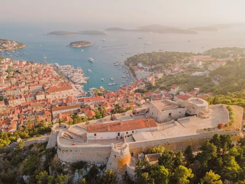 Aerial view of Hvar Town from the fortress showing the harbour, rooftops and nearby islands, a well known highlight for travellers exploring Croatia by boat.