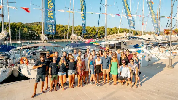 Group of people pose for a photo in front of MedSailors yachts