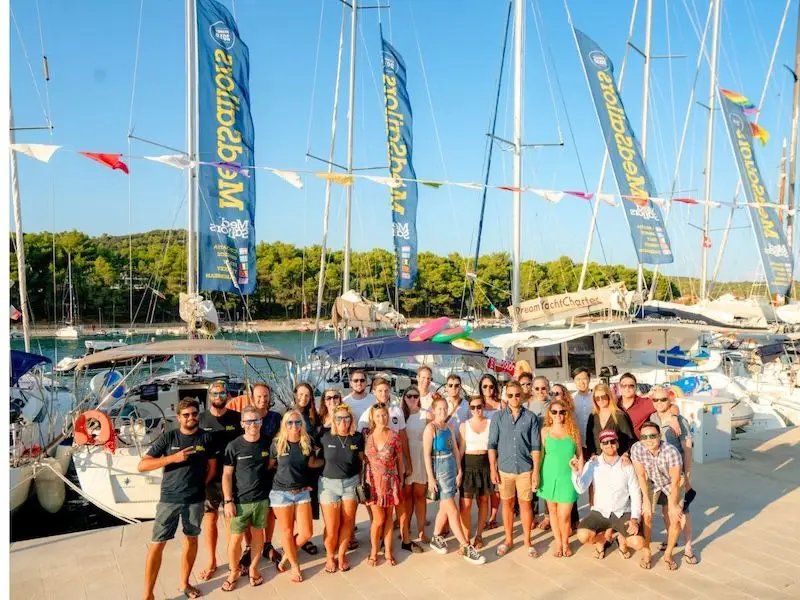 A group of travellers stand in front of yachts in Stari Grad Croatia while on their adventure yacht week with MedSailors.