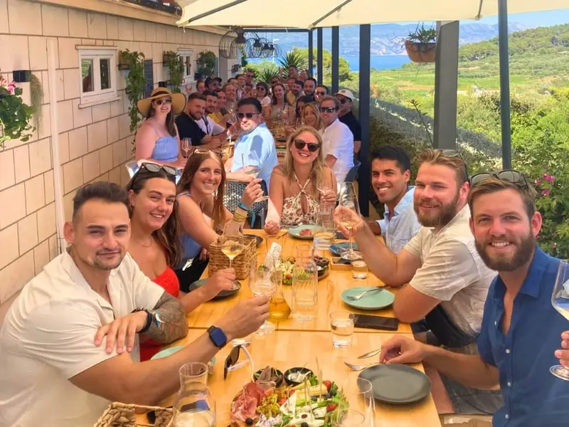 MedSailors travellers enjoying a group meal together during a Croatia island-hopping sailing holiday, overlooking the Dalmatian coast.