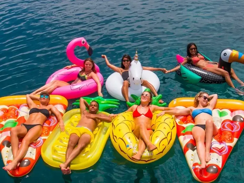 Group of girls floating in a beautiful bay in Greece while on a hen do bachelorette trip on a yacht week with MedSailors.