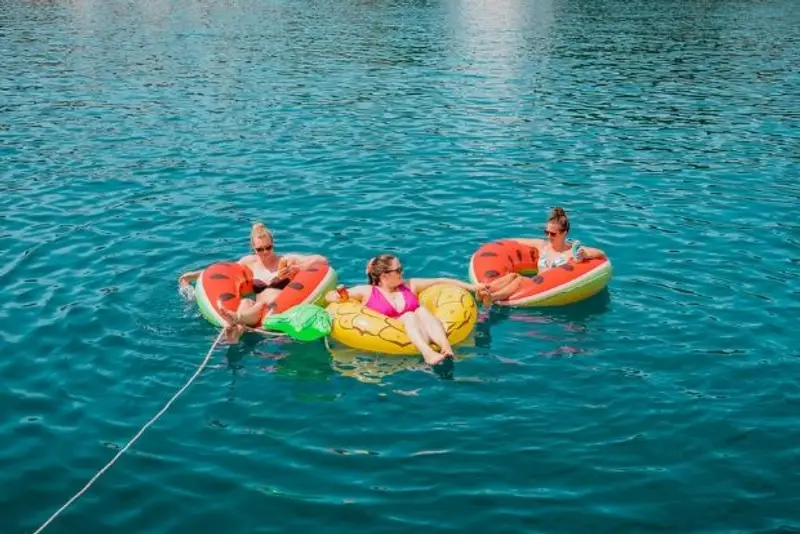 Guests floating on floaties with a drink