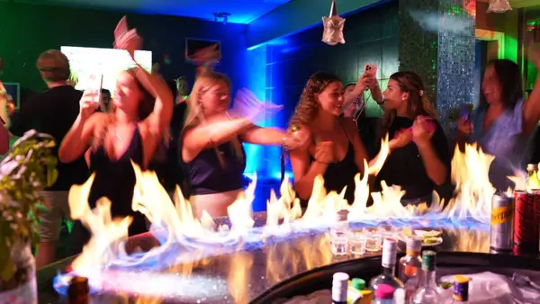 Group of young travellers on a social island hopping tour with MedSailors dancing in a Greek seaside club on Ermioni.