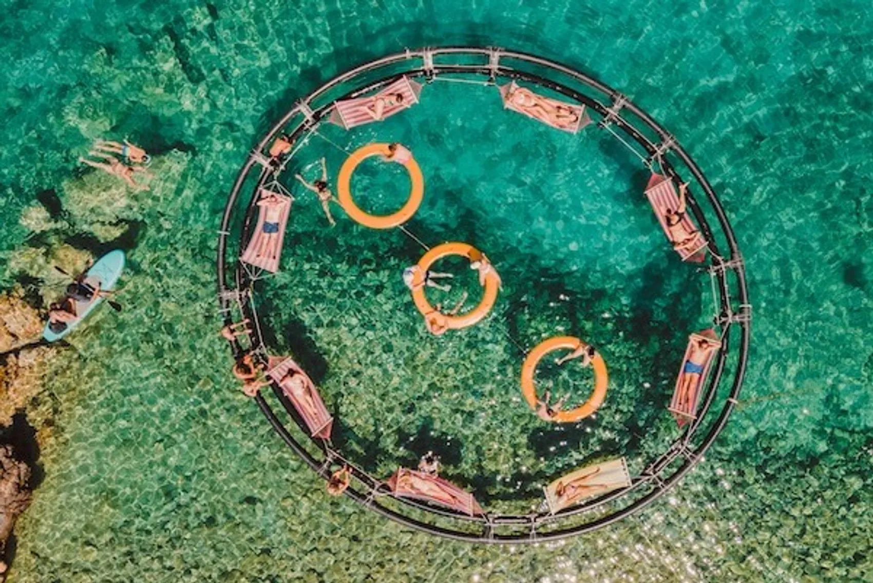 Floating hammocks and bar at Aponisos beach club in Agistri Greece