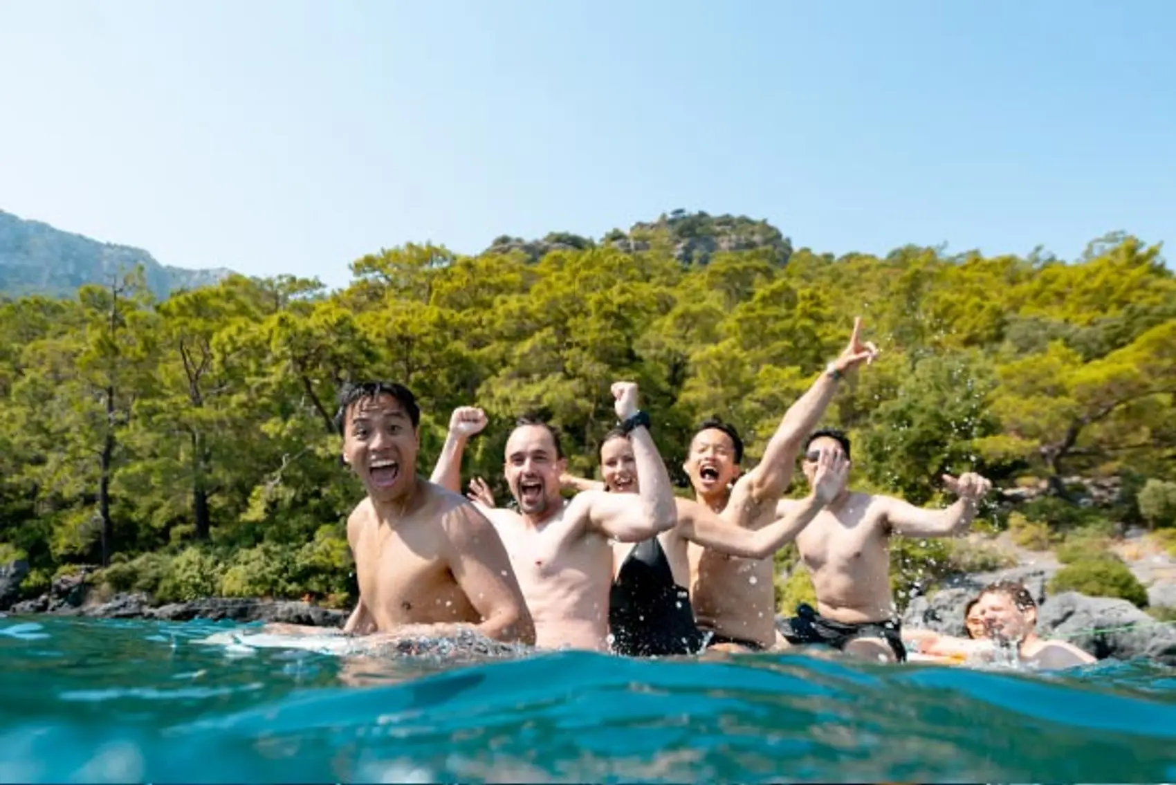 Friends together on a paddle board in Greece