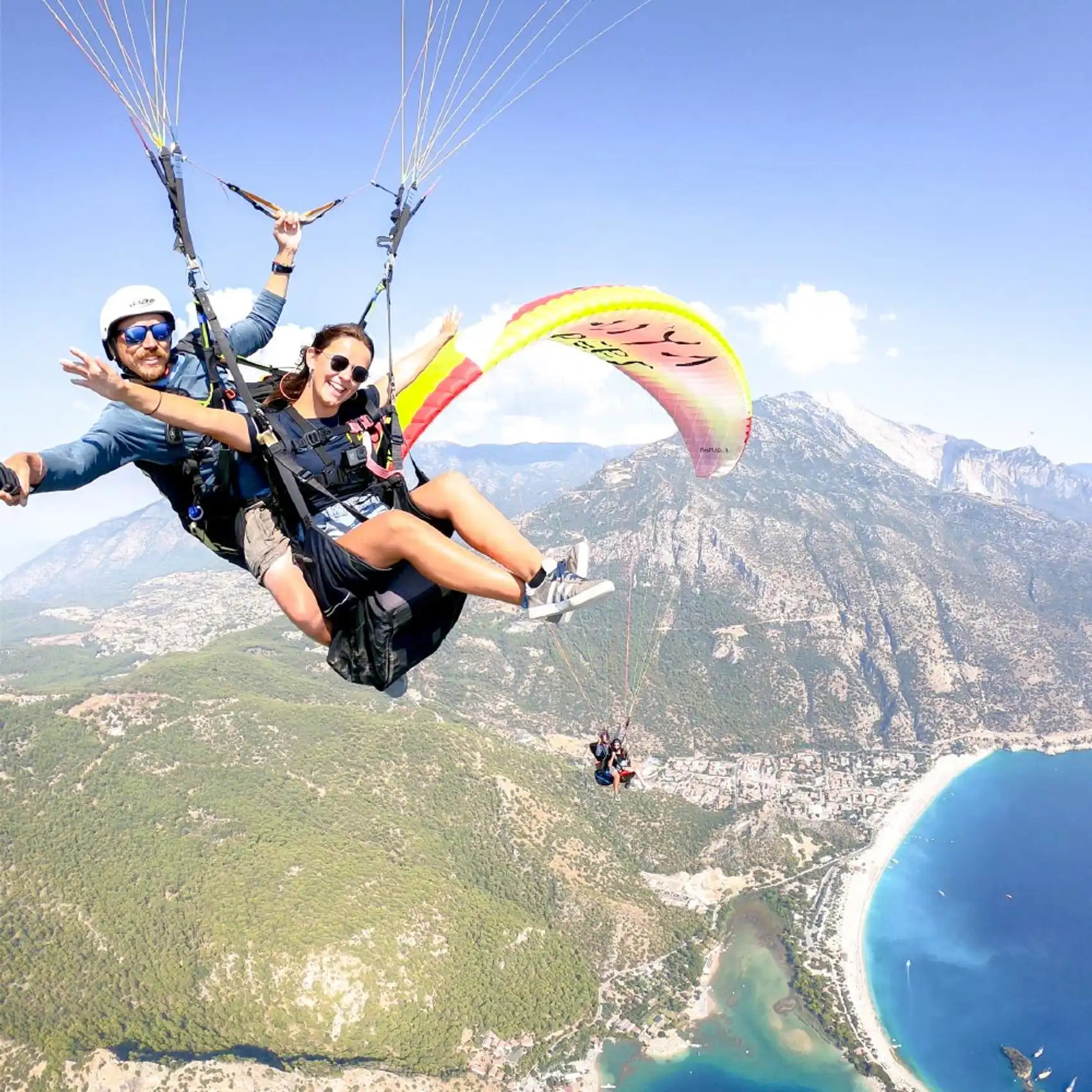 Two people tandem paragliding over Oludeniz beach in Turkey