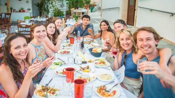 Group of friends pose for a photo at a Greek restaurant