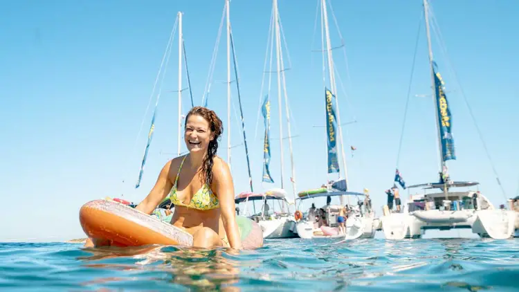 Woman relaxing on a floatie in front of MedSailors yachts