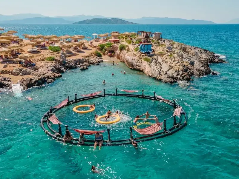 Aerial drone photo of Aponisos and the blue lagoon on Agistri island in Greece. This is one of the best party destinations in the Mediterranean.