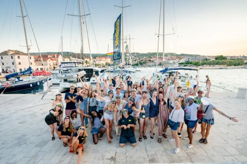 Image of group of people in front of a yacht