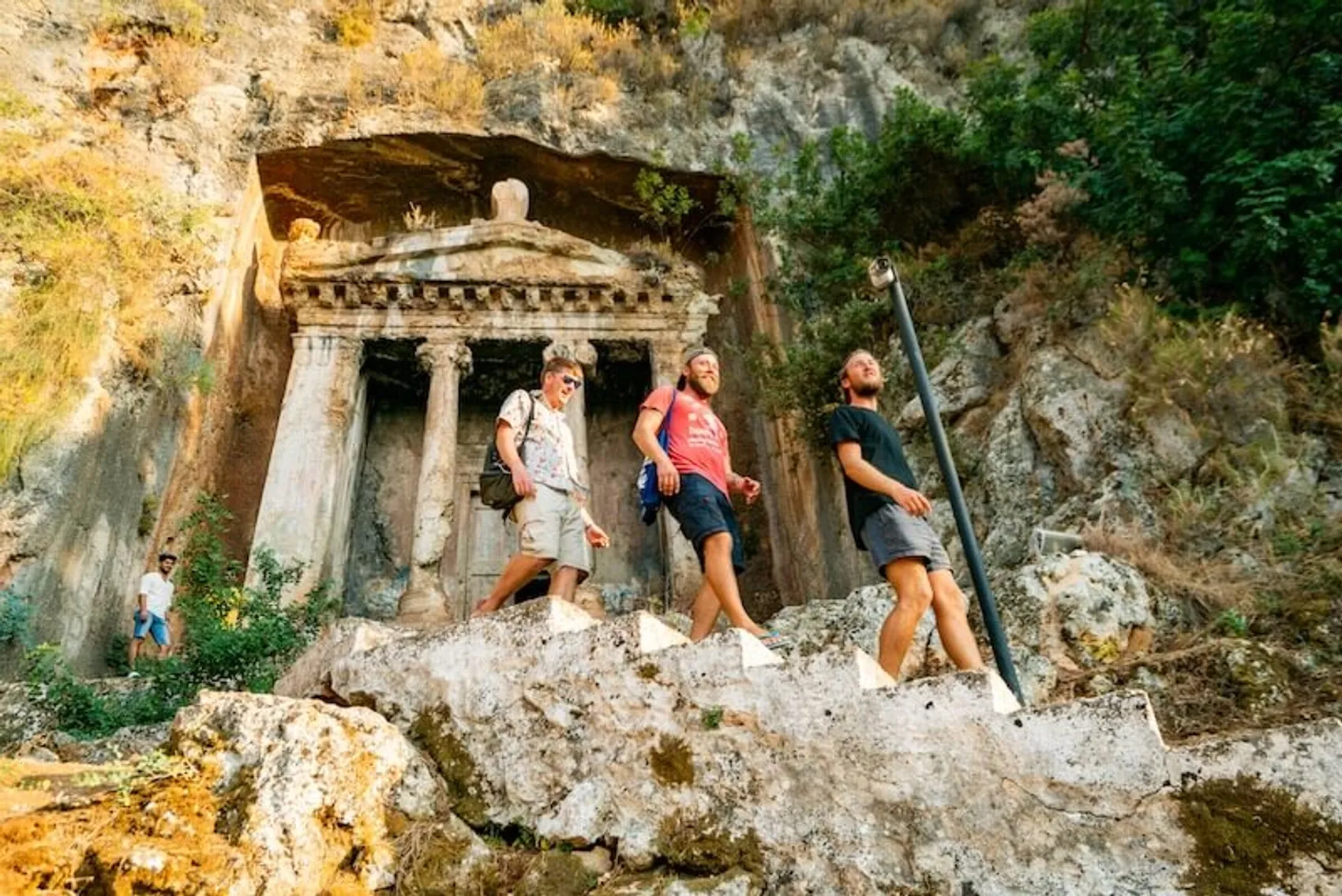 Group pf people walking past Lycian ruins near Fethiye in Turkey.