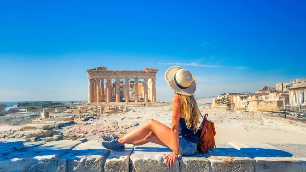 Woman posing for a photo in front of the Acropolis in Greece