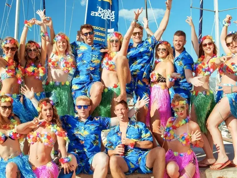 Group of people in floral island outfits on a stag do and hen do group trip sailing Croatia and Greece with MedSailors.