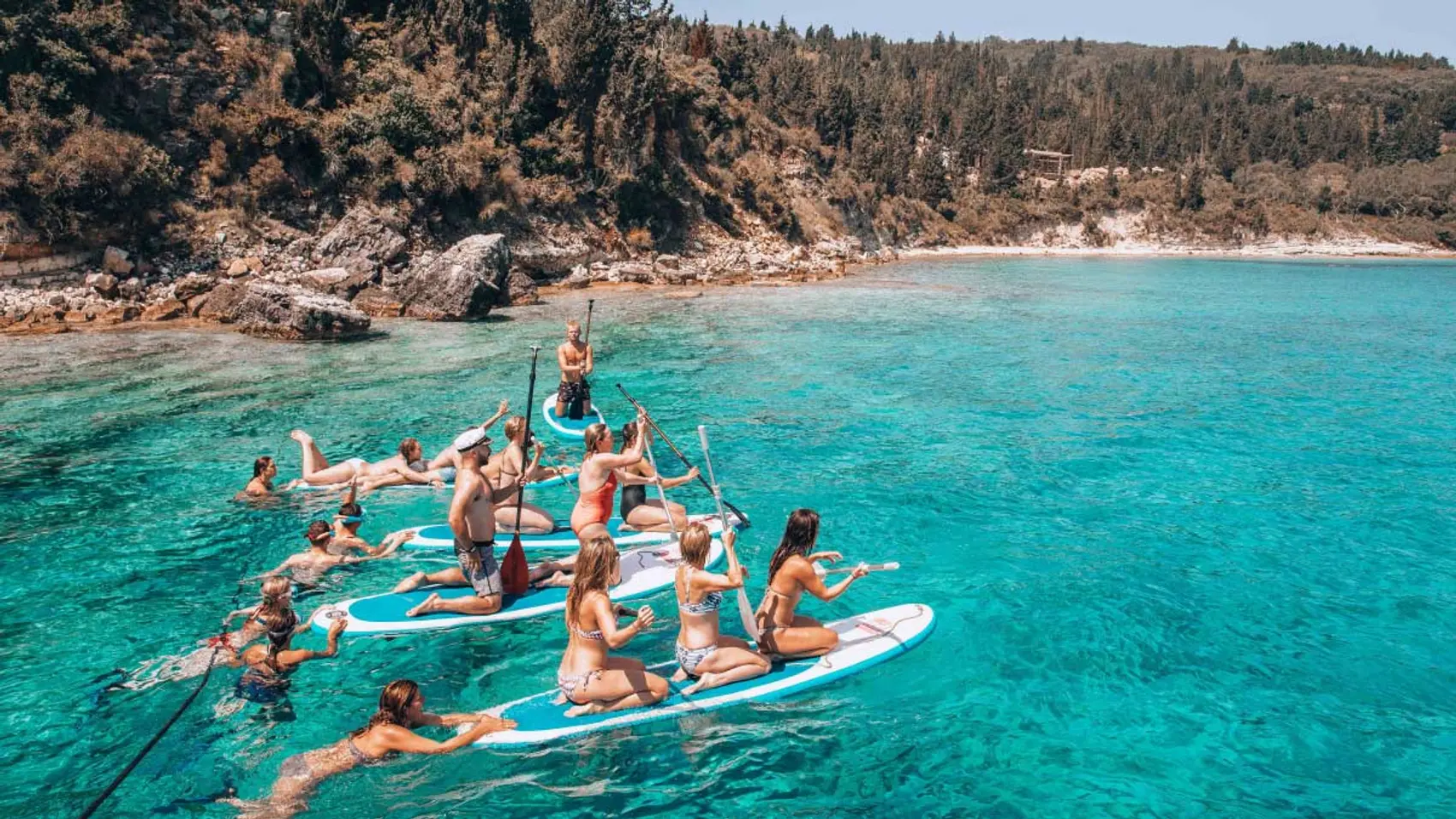 Group of people racing on paddle boards in Greece