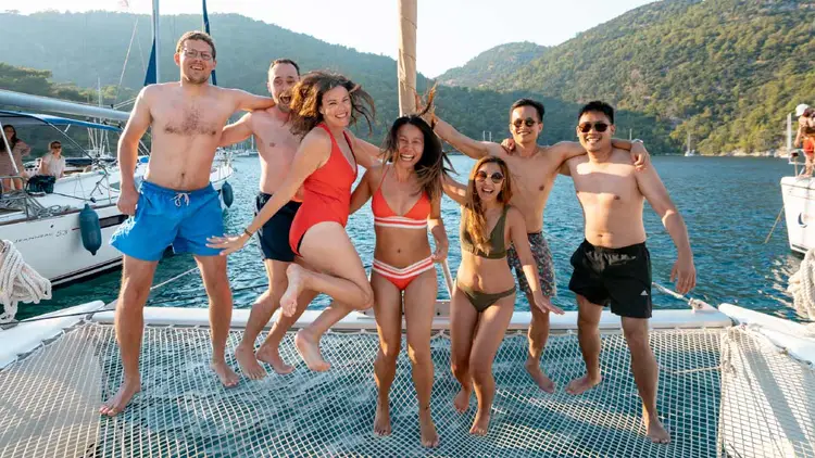 Guests jumping on the bow of a catamaran