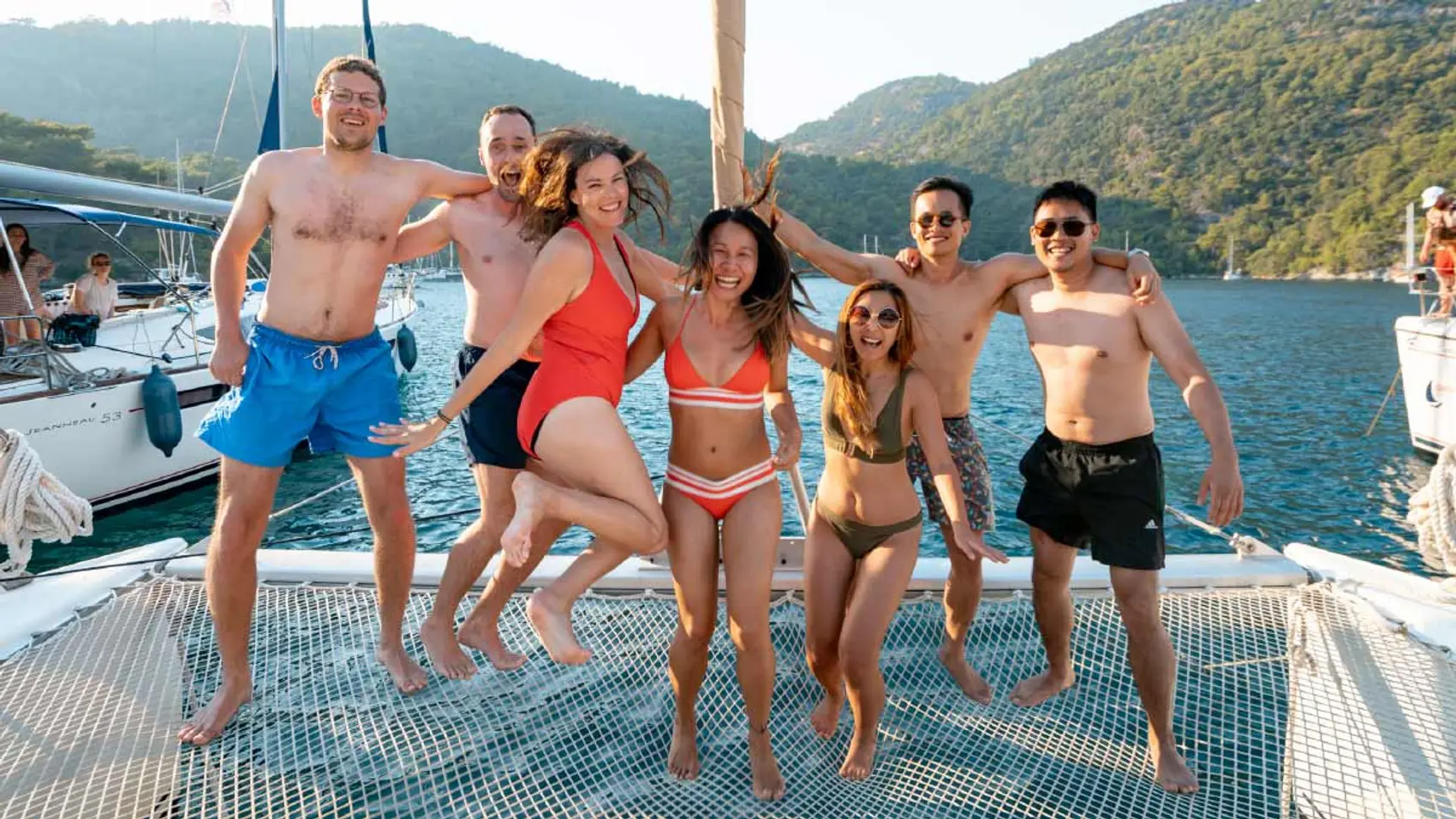 Guests jumping on the bow of a catamaran