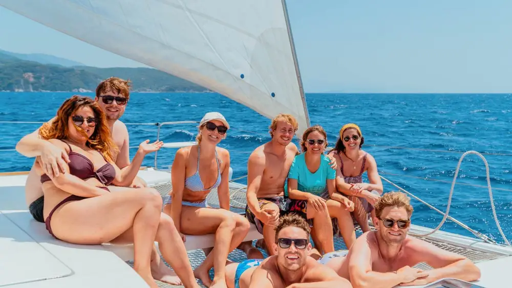 Group of friends sitting on a catamaran