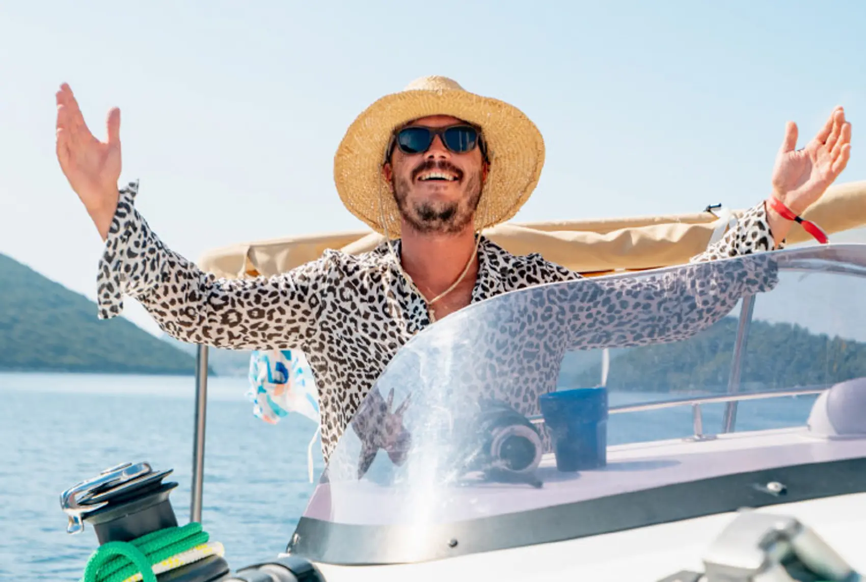 Man wearing a wide brimmed hat on a yacht