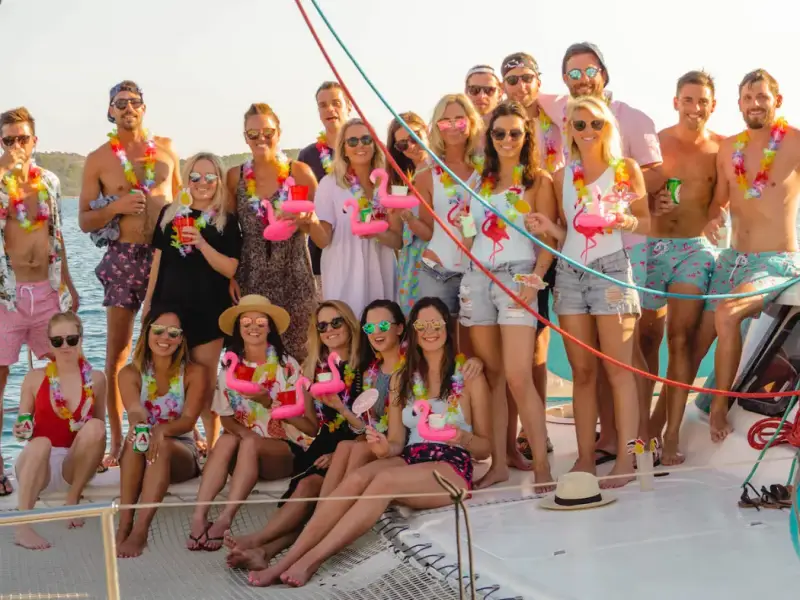 Group of travellers in festival-style outfits posing together on a MedSailors yacht in Croatia, showing the social side of combining Ultra Europe in Split with a Croatia sailing holiday. Image for a budget guide about saving money on a festival trip, meeting people, and adding yacht accommodation, swim stops, and island hopping with MedSailors.