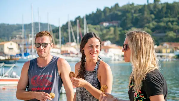 Group of people eating some food on the waterfront in Lakka