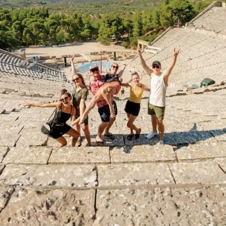 Group of MedSailors travellers visiting an ancient Greek theatre during a Greece sailing holiday, combining island hopping with local cultural experiences.