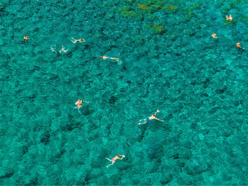 Aerial view of travellers swimming in clear turquoise water in Croatia during a MedSailors sailing holiday. Image for a budget guide about adding Croatia island hopping, swim stops, and yacht travel to an Ultra Europe festival trip in Split.