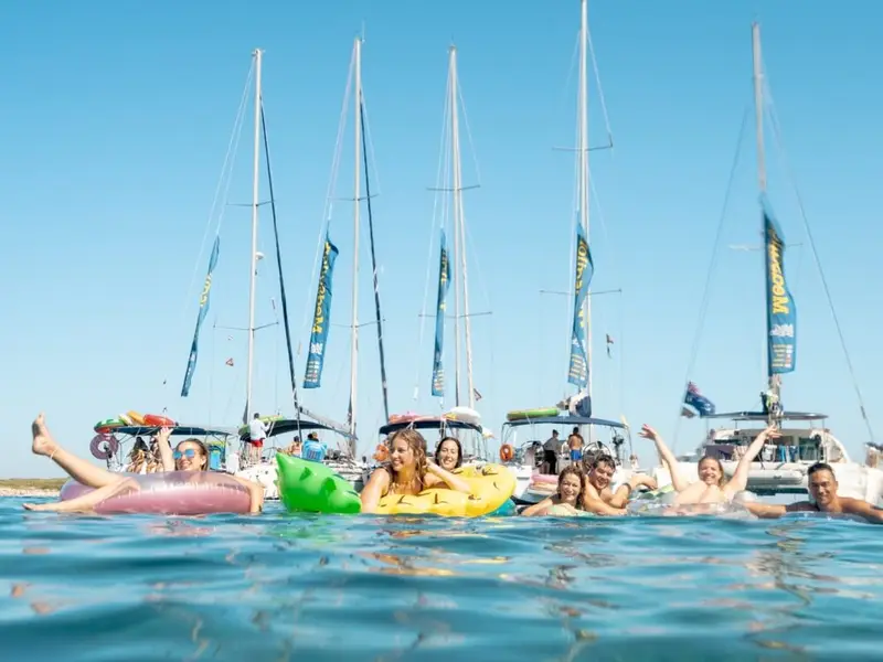 MedSailors travellers swimming and relaxing in the clear Adriatic Sea beside sailing yachts during a Croatia island-hopping holiday.
