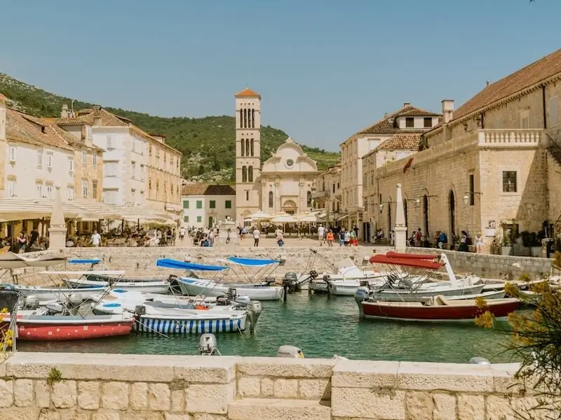 Small boats moored in the historic Croatian harbour of Hvar town along the Dalmatian Coast on a sunny day.