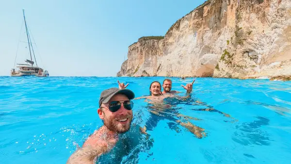 Group of people swim in blue water in Greece