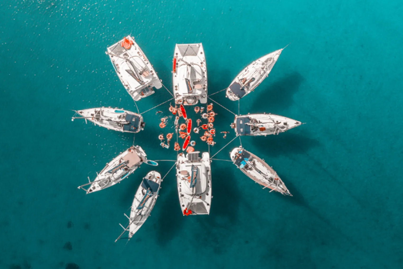 A star raft of yachts in a blue bay in the Mediterranean.