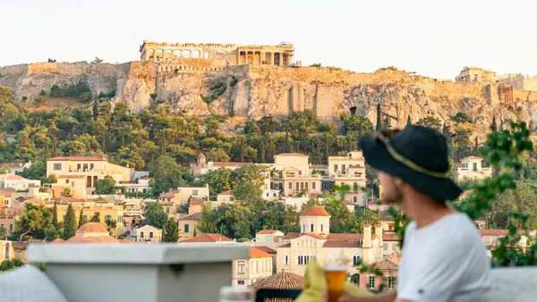 Man on a roof terrace overlooking the Acropolis in Athens