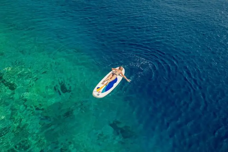 A girl paddle boarding in Croatia.