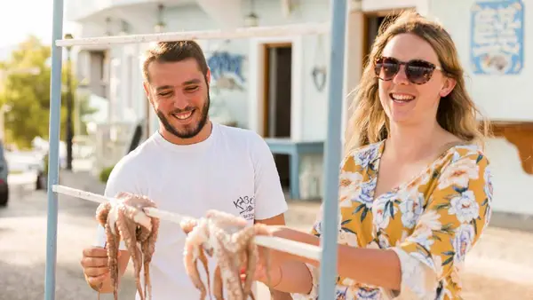 Woman looking at fresh octopus in Greece