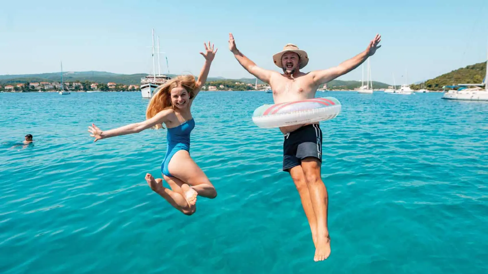 Two people jump into the water in Greece