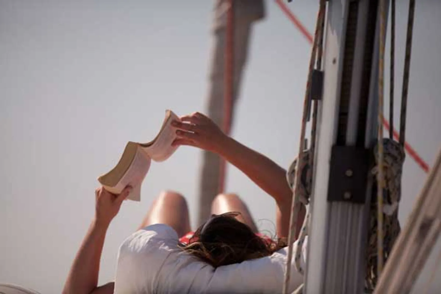 Person reading a book on a yacht.