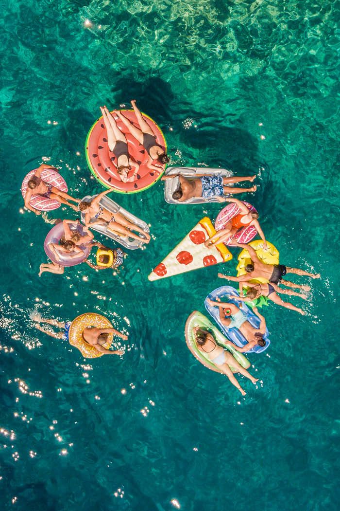 Friends on some floaties in blue water