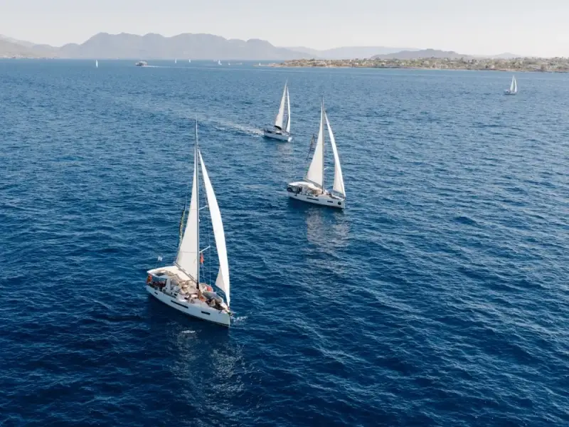 Group portrait of four smiling hospitality team members behind a bar with bottles on shelves, representing local partners involved in MedSailors trips.