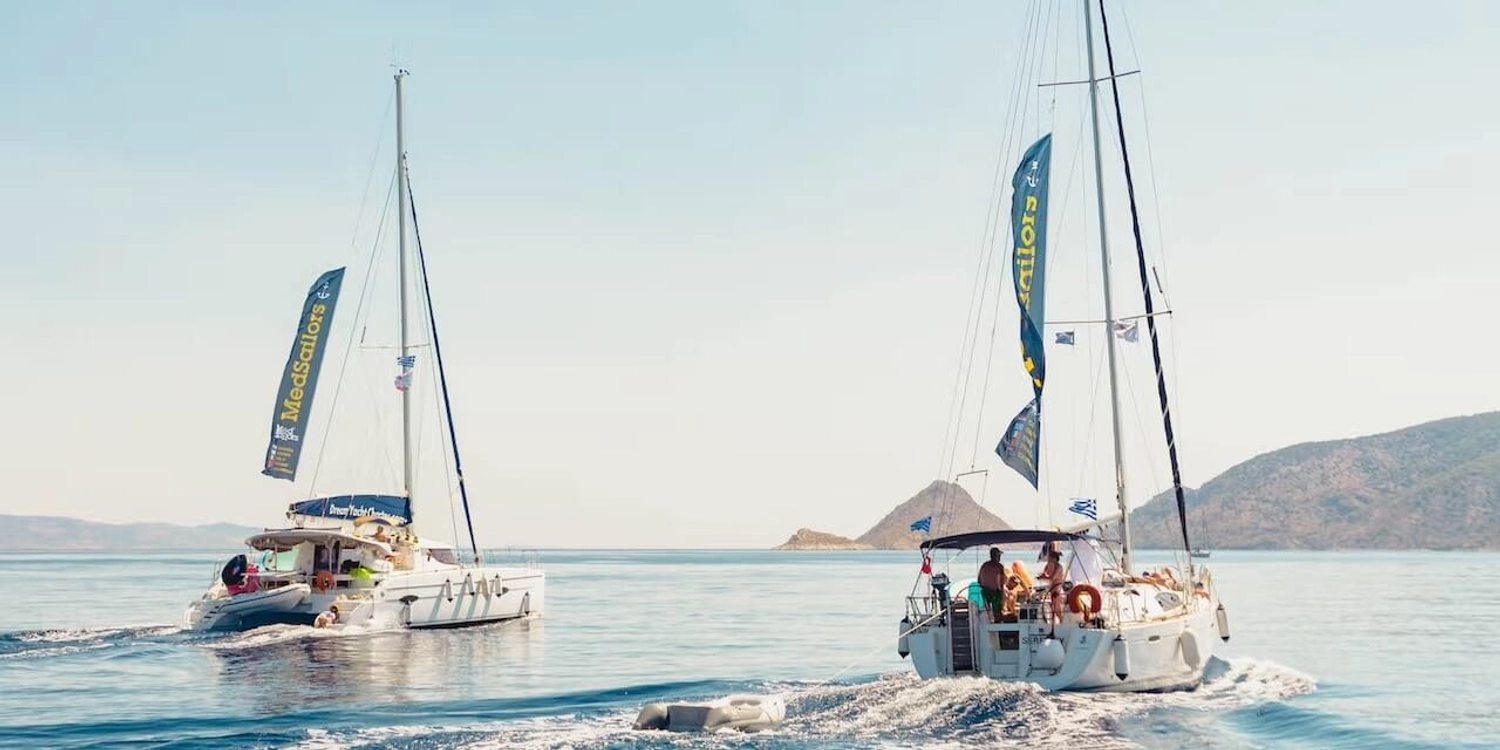 Two sailing yachts, a catamaran and a monohull, cruise to Mediterranean islands on a Greece or Croatia island hopping tour.