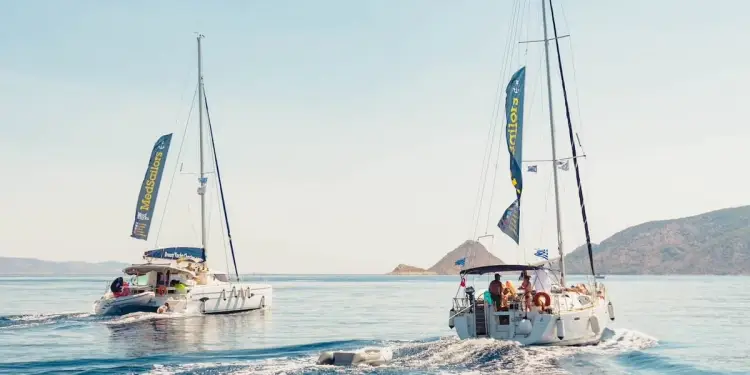 Two sailing yachts, a catamaran and a monohull, cruise to Mediterranean islands on a Greece or Croatia island hopping tour.