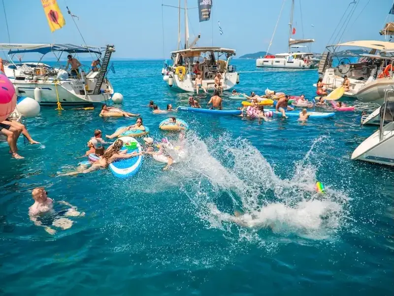 Group on young travellers swimming and partying in a bay in the Mediterranean while on a yacht week with MedSailors.