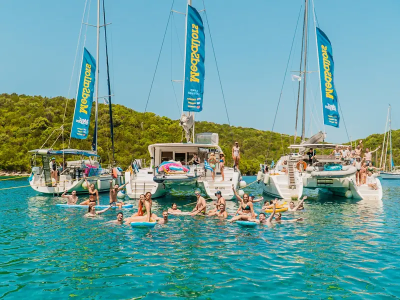 Kiwi and Aussie exchange students on an adventure tour in Europe sailing with MedSailors. People swim and relax in a beautiful bay together on yachts.